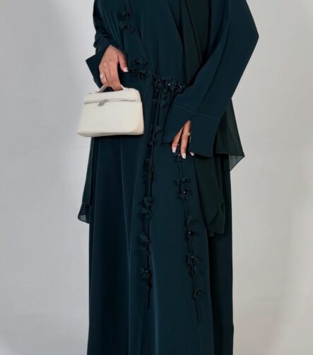 Elegant deep teal abaya featuring delicate 3D floral detailing with pearl-beaded flower centres, inner and outer tie closures Comes with a premium chiffon scarf Fabric - Korean nida Colours - Teal | Berry