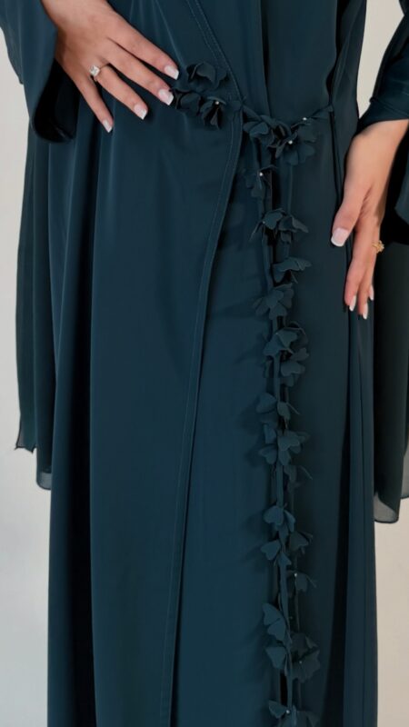 Elegant deep teal abaya featuring delicate 3D floral detailing with pearl-beaded flower centres, inner and outer tie closures Comes with a premium chiffon scarf Fabric - Korean nida Colours - Teal | Berry By pardah